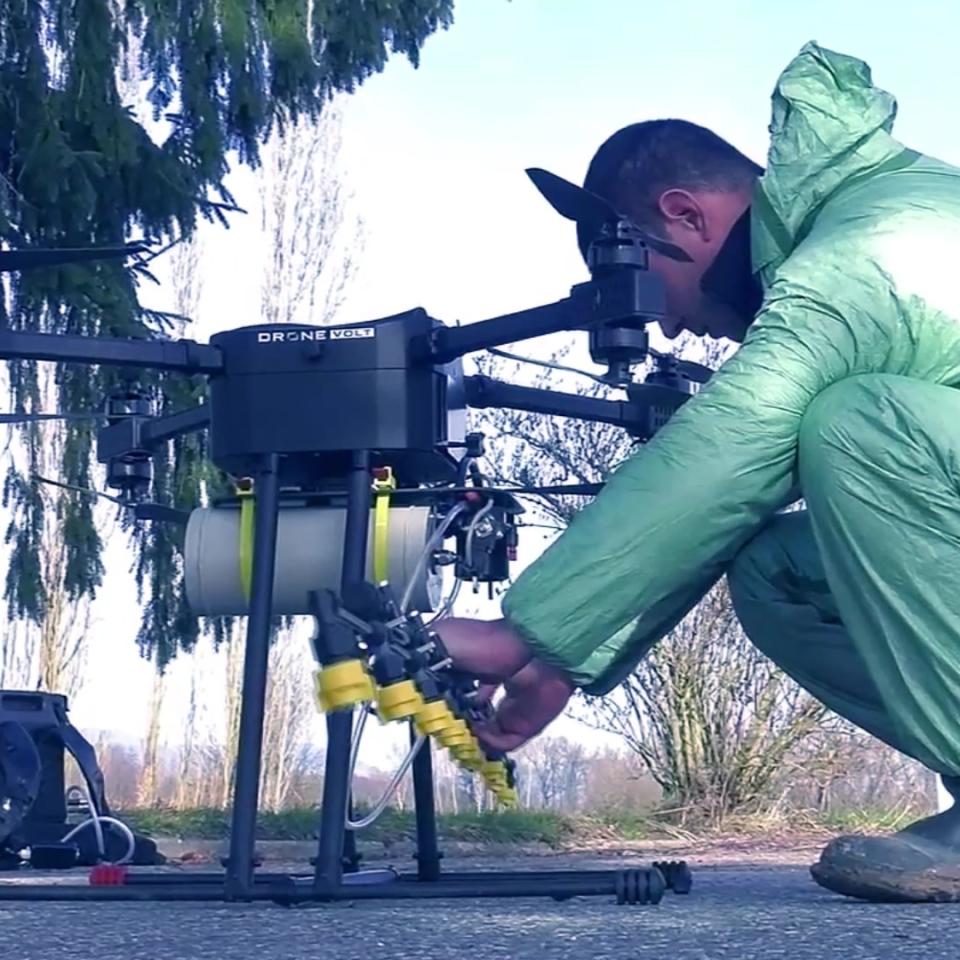 Full life cycle franchise model: Man equipped with a green jumpsuit preparing a cleaner drone for launch