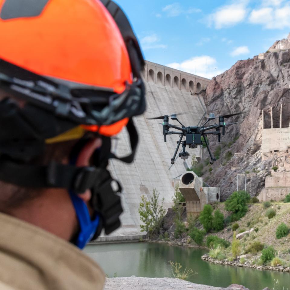 Service package selection: Firefighter piloting a drone near a dam.